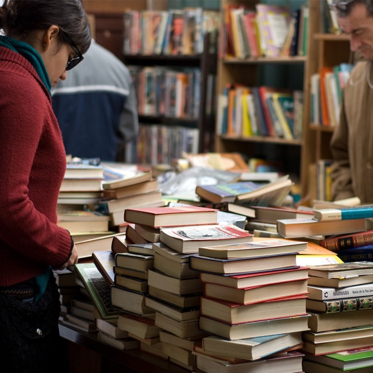Två personer tittar i ett stånd med begagnade böcker