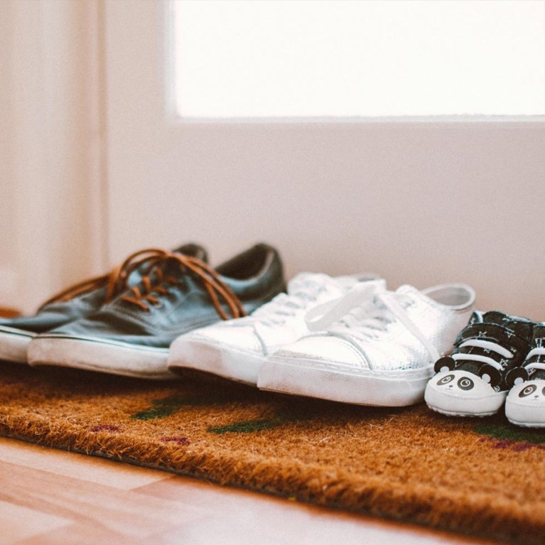 Tre par skor på en dörrmatta