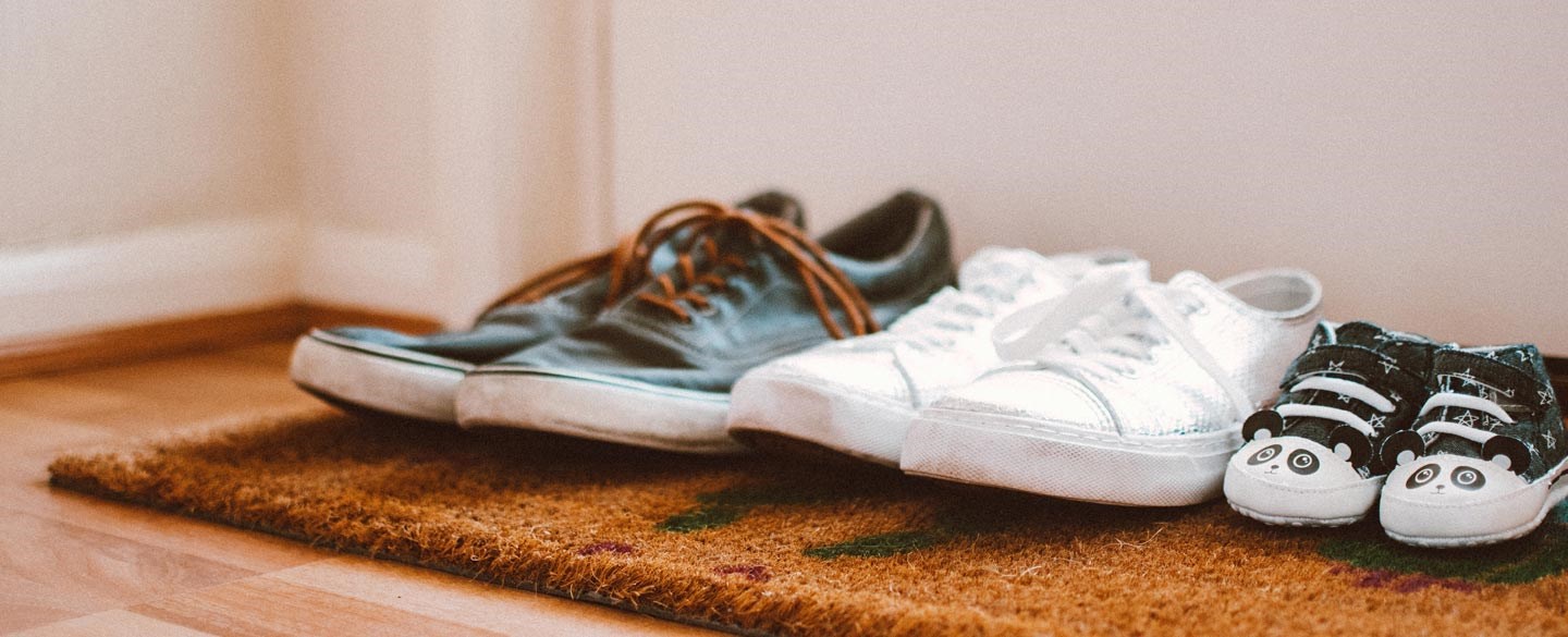 Tre par skor på en dörrmatta