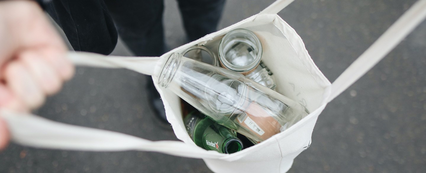 Närbild på tygkasse med glasförpackningar