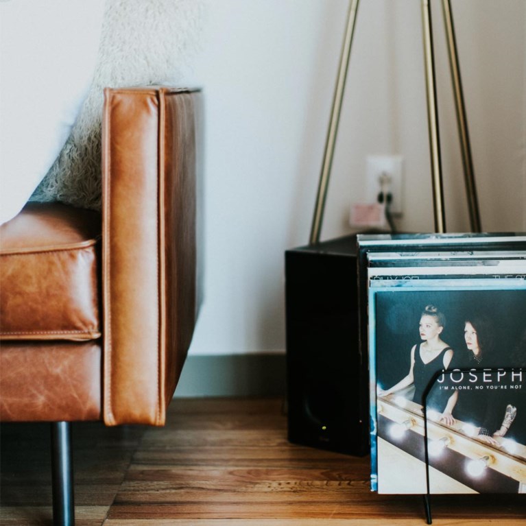 På bilden ser man en brun soffa och vinylskivor
