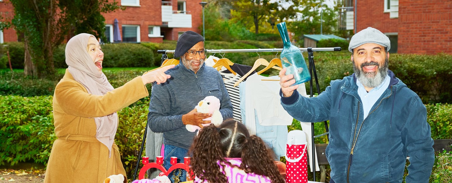 en man håller upp fynd på loppmarknad, en flaska.