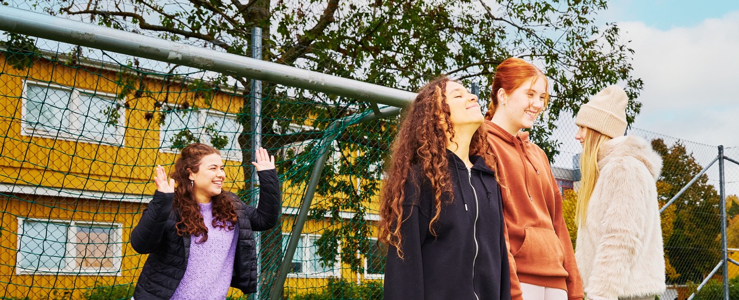 unga tjejer står framför fotbollsmål