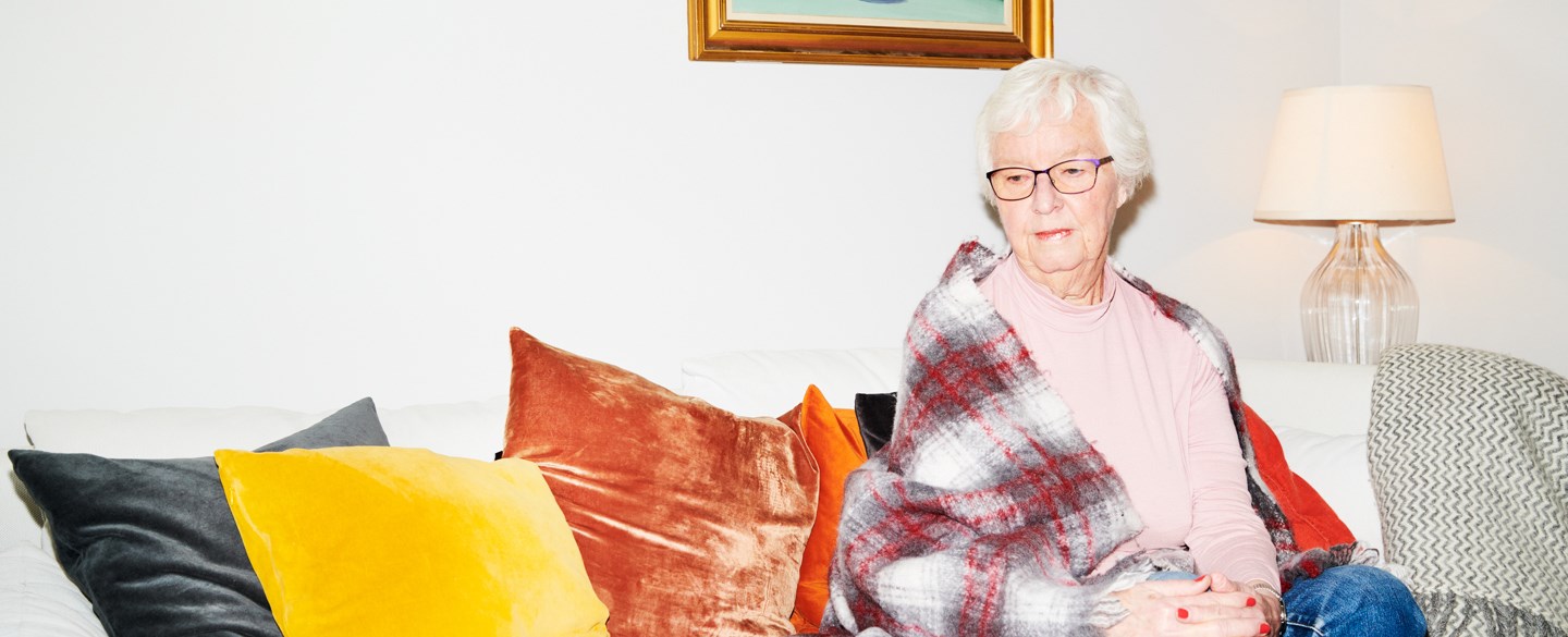 En dam sitter i en soffa.