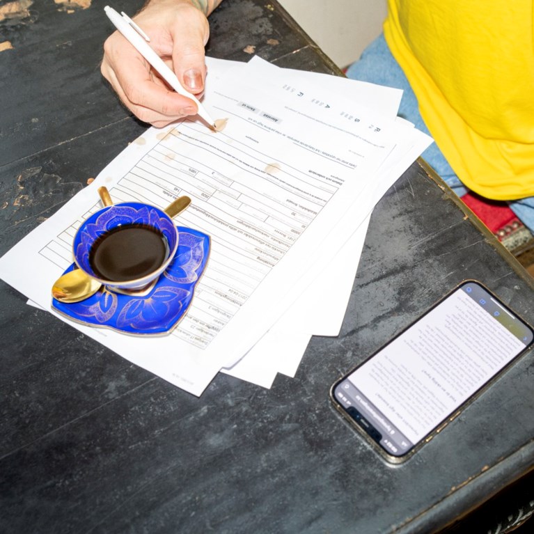 En man skriver på ett papper.