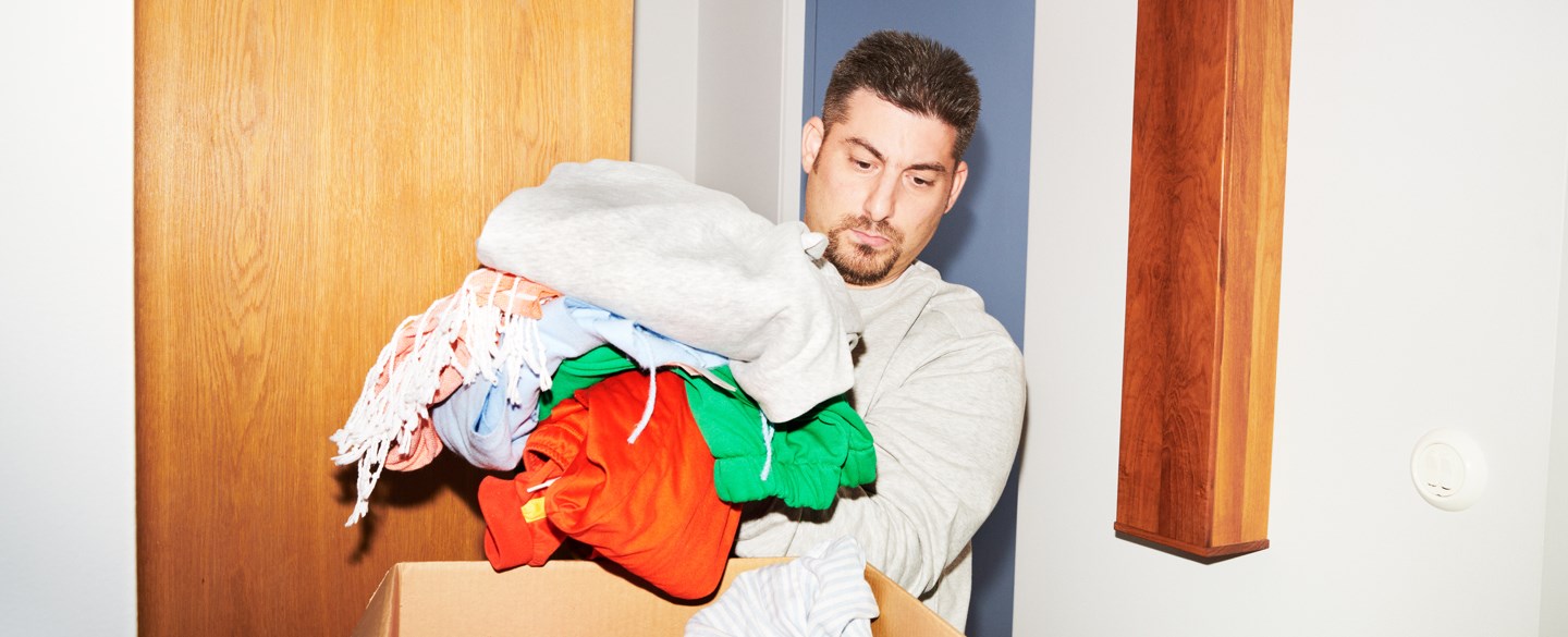 En man flyttpackar kläder.