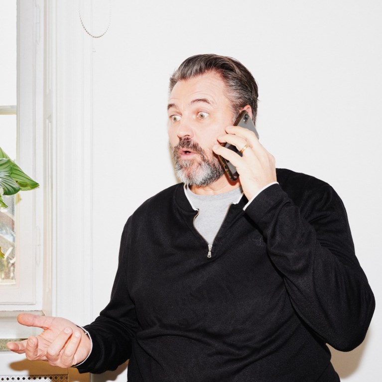 En man pratar i telefon, han ser upprörd ut