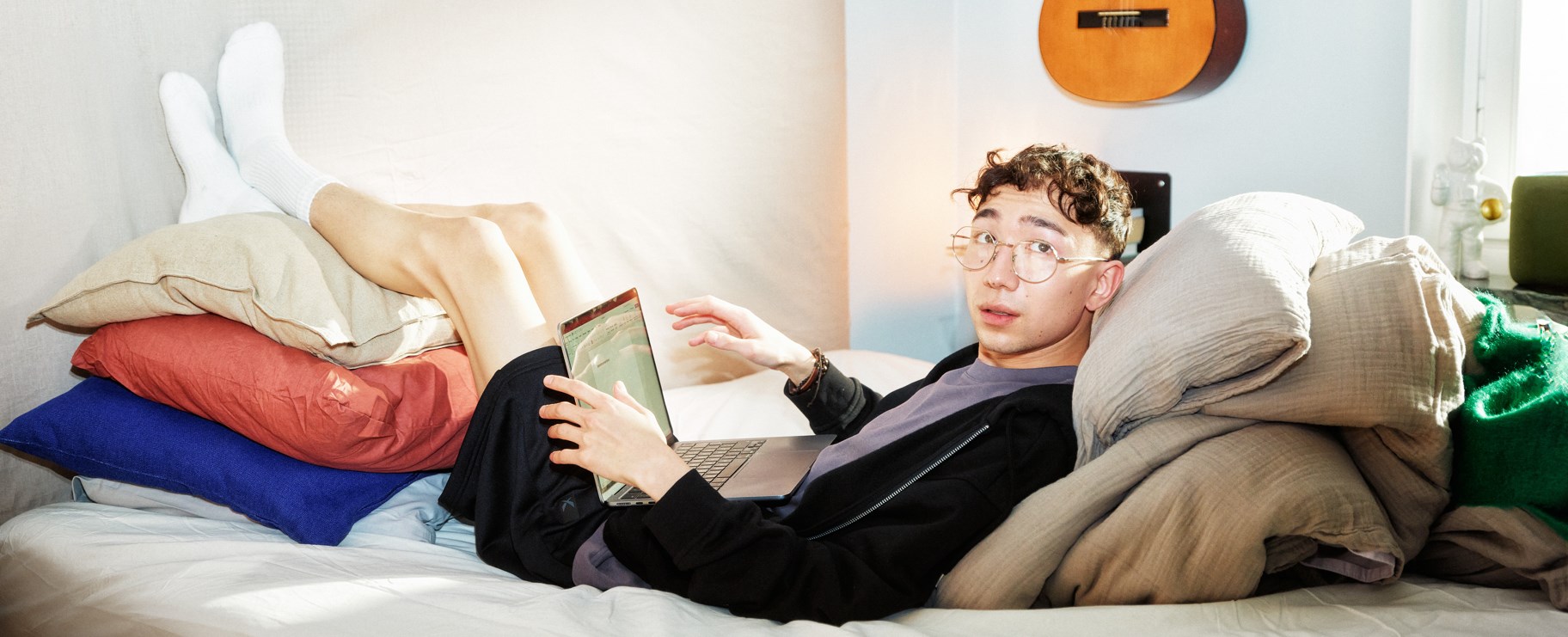 kille ligger med dator i knät