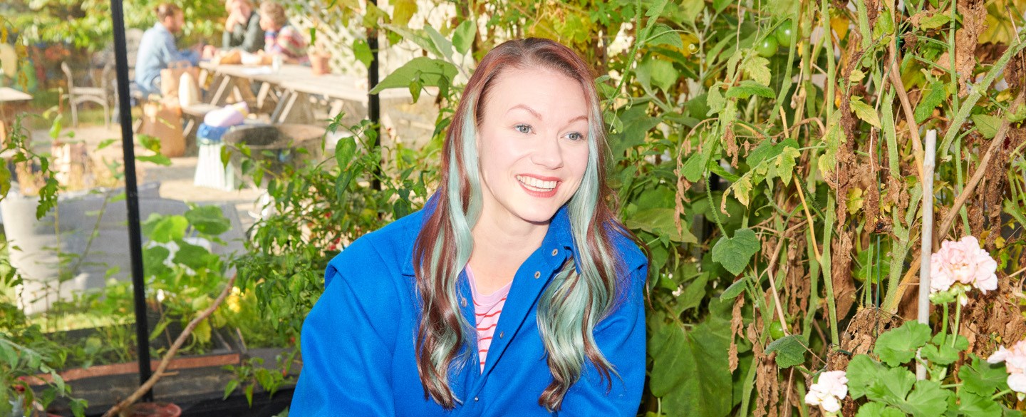 Leende kvinna vid trädgårdsbord