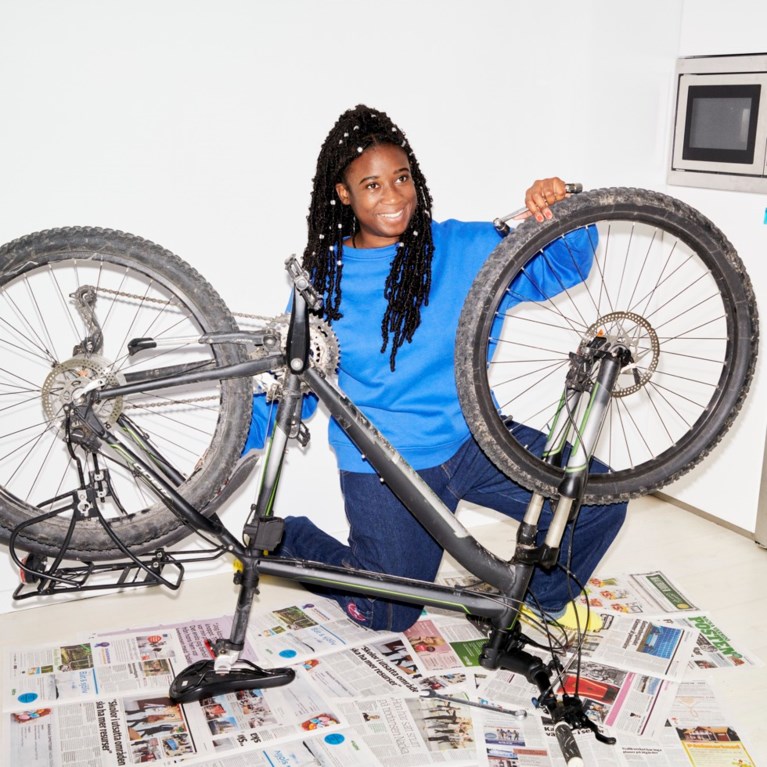 En kvinna lagar sin cykel i köket.