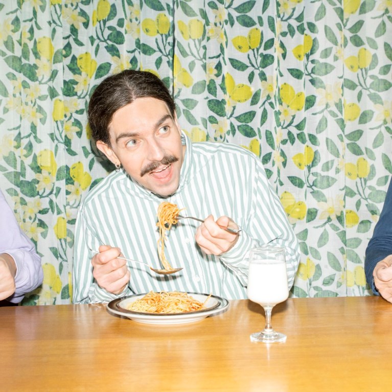 Tre personer äter pasta.