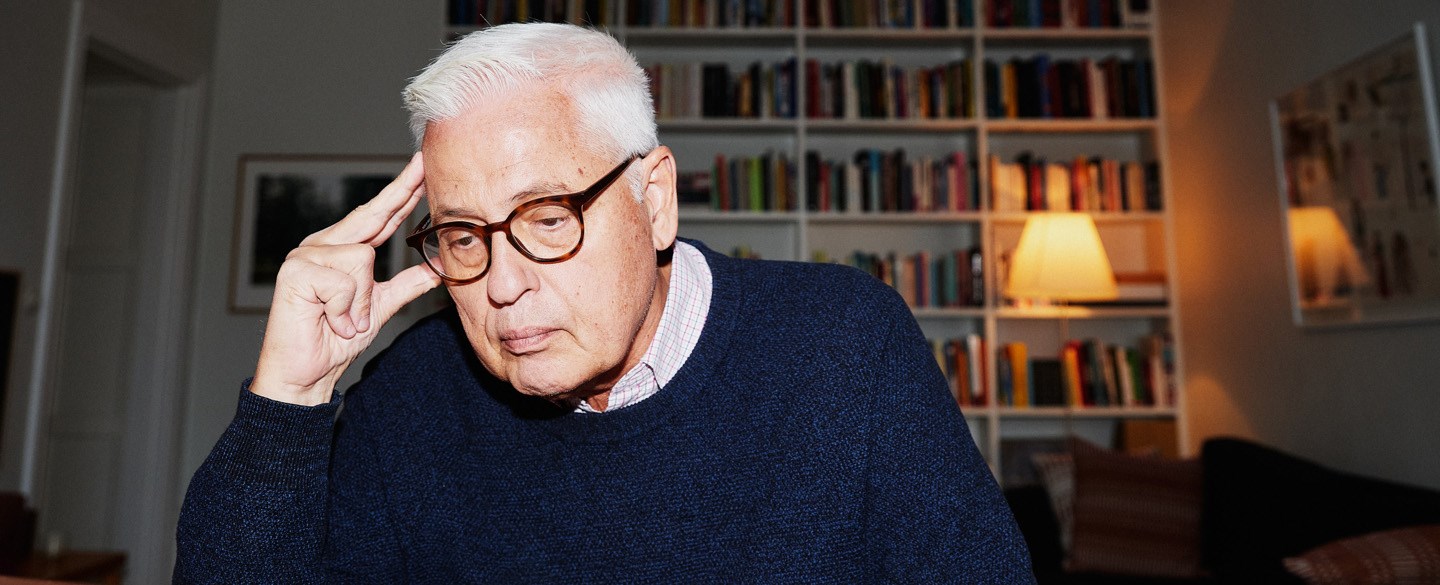 En man sitter framför en dator och ser fundersam ut.