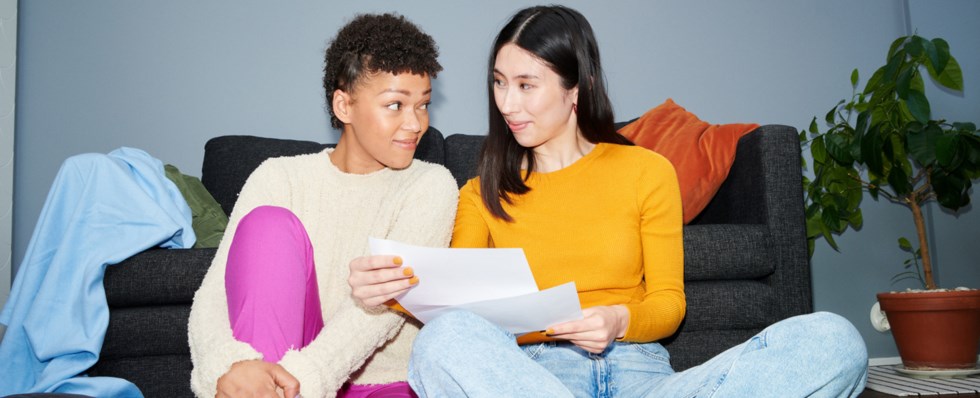 Två personer läser på ett papper.