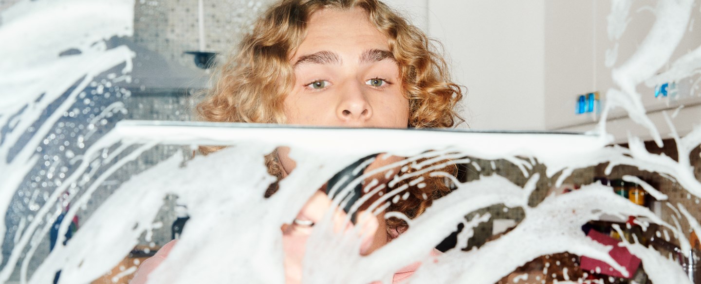 En kille skurar en glasskiva