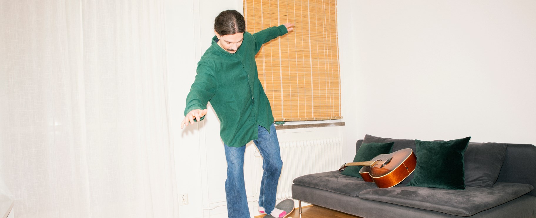 man balaserar på skateboard i lägenhet