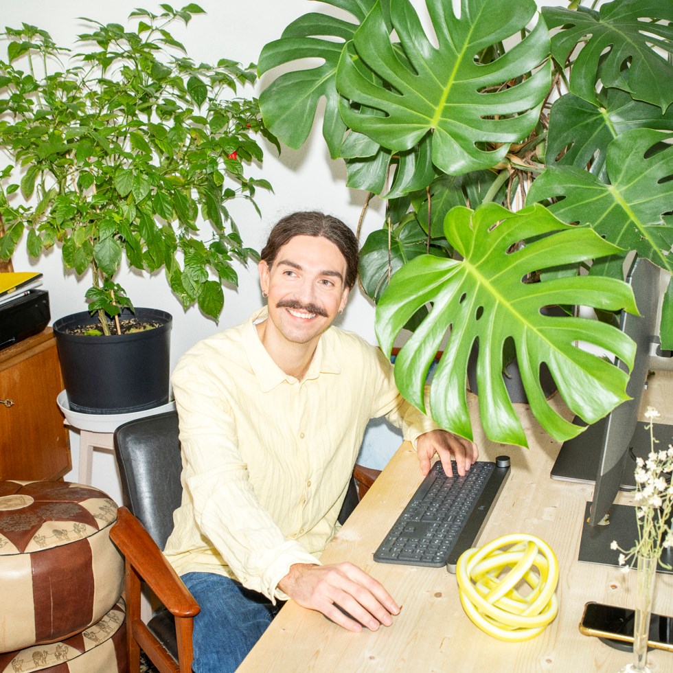 man jobbar vid dator bland växter