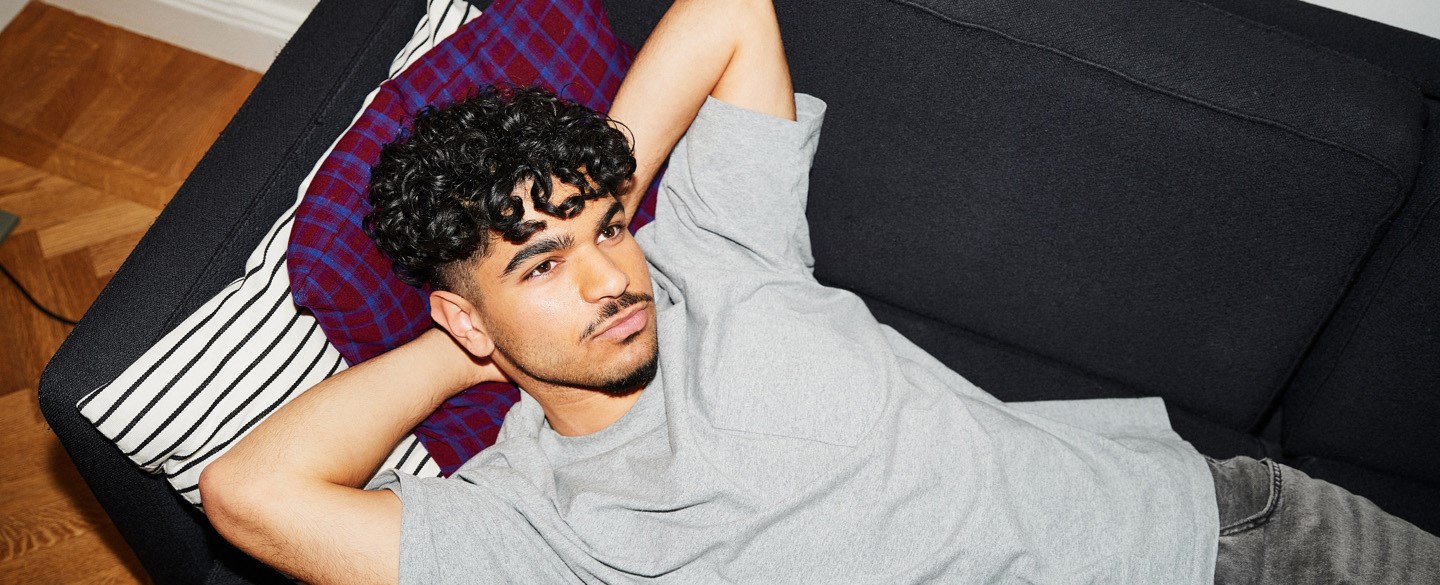 En kille ligger på soffan och vilar