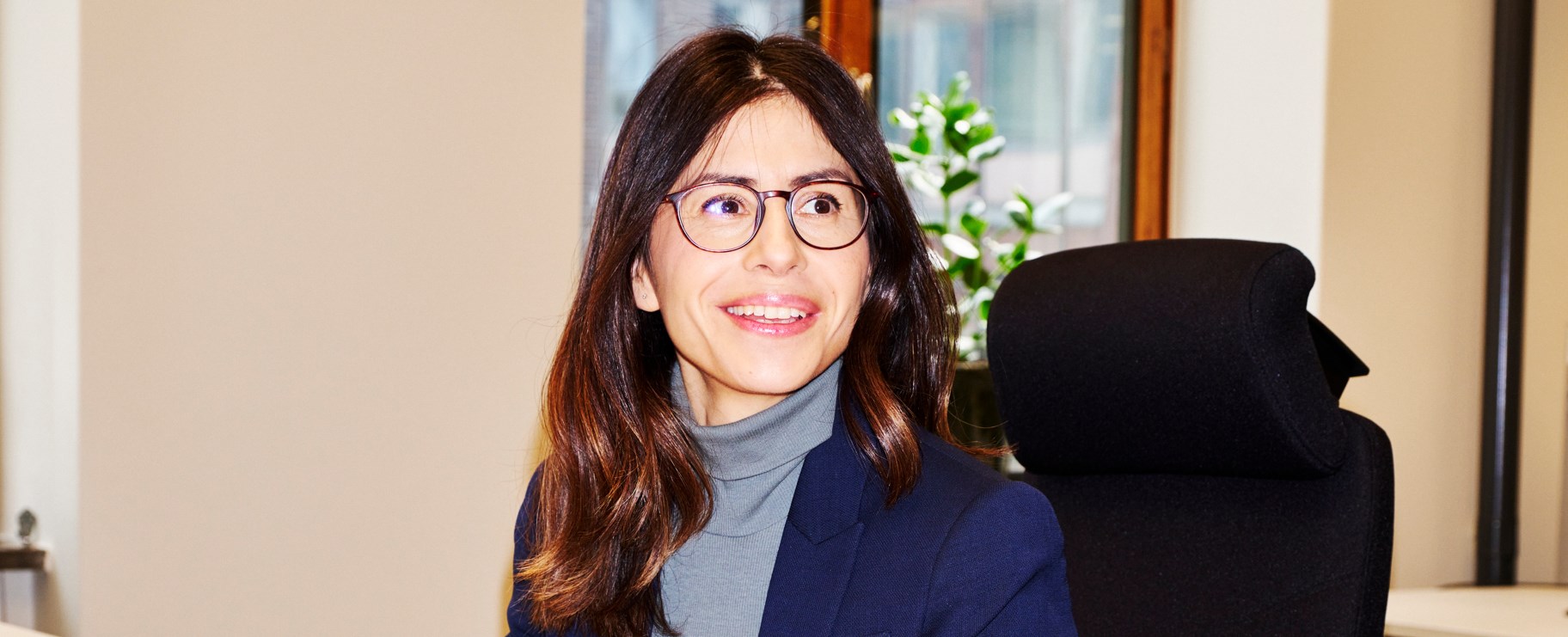 Kvinna i blå kavaj på kontor lagbok