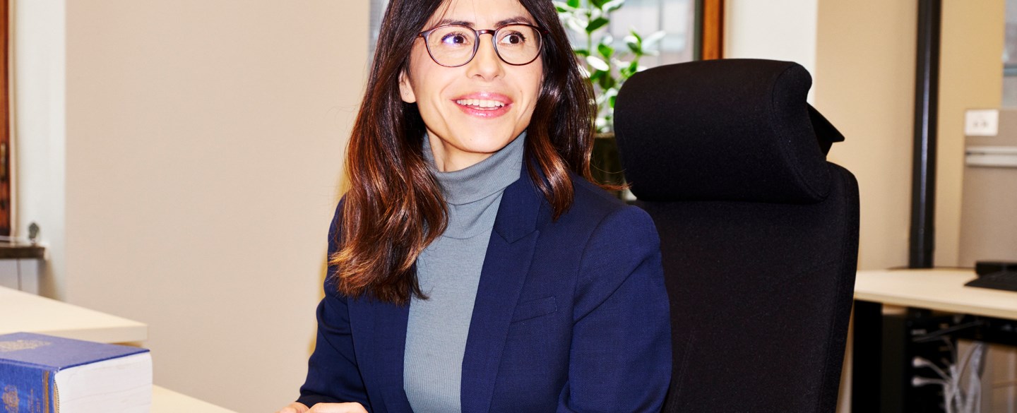 kvinna i blå kavaj vid dator