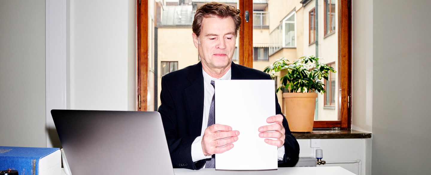 En jurist vid skrivbord samlar ihop sina papper