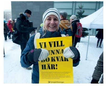 En kvinna håller ett plakat med texten Vi vill kunna bo kvar här!