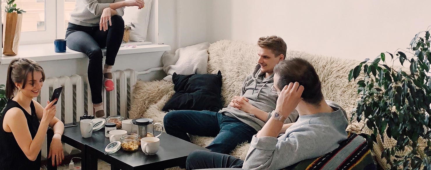 Fyra ungdomar fikar i ett vardagsrum