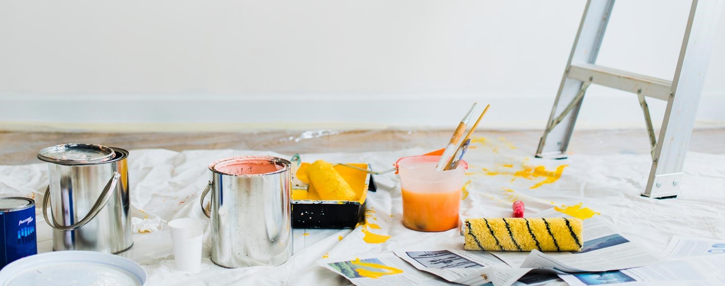 På bilden ser man målarburkar och en stege i ett rum